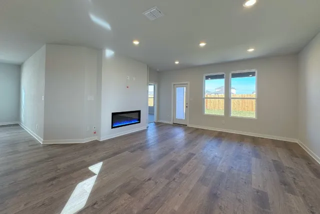 an empty room with wooden floor and fireplace