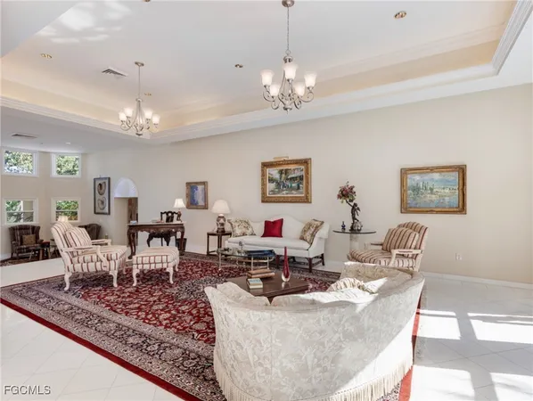 a living room with furniture chandelier and a rug
