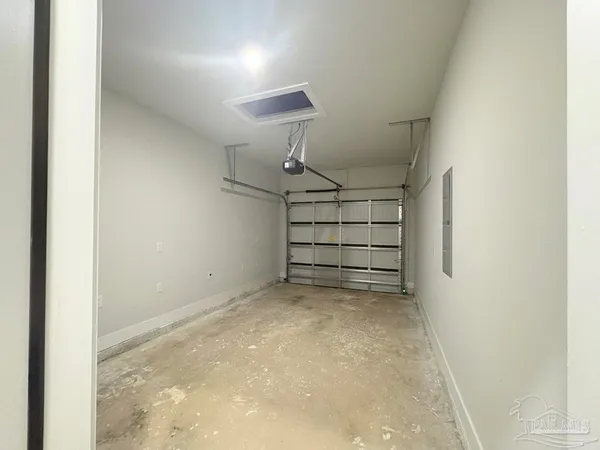 an empty room with wooden floor cabinet and windows