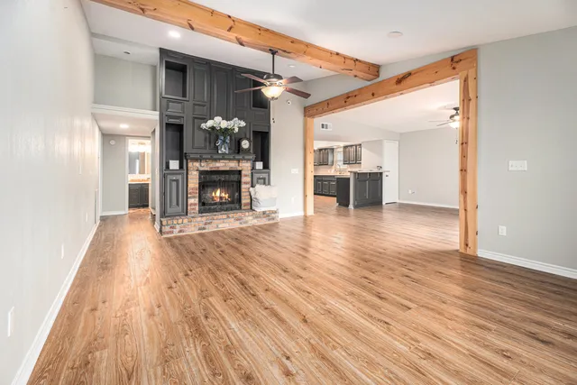 a view of a livingroom with a fireplace wooden floor and window