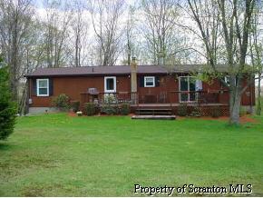 1240 McCarty Road Nicholson, PA 18446 - Photo 1 of 2 a front view of house with yard and outdoor seating