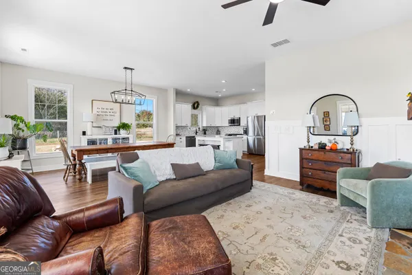a kitchen with stainless steel appliances granite countertop a sink a stove a refrigerator cabinets and a window