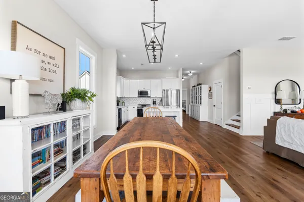 a view of a kitchen with a refrigerator a stove top oven a sink and cabinets