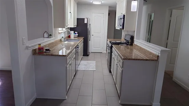 a en suite bathroom with a granite countertop sink and a mirror