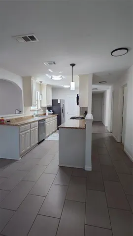 a large kitchen with a stove a sink dishwasher and a refrigerator