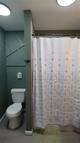 a bathroom with a toilet and a shower