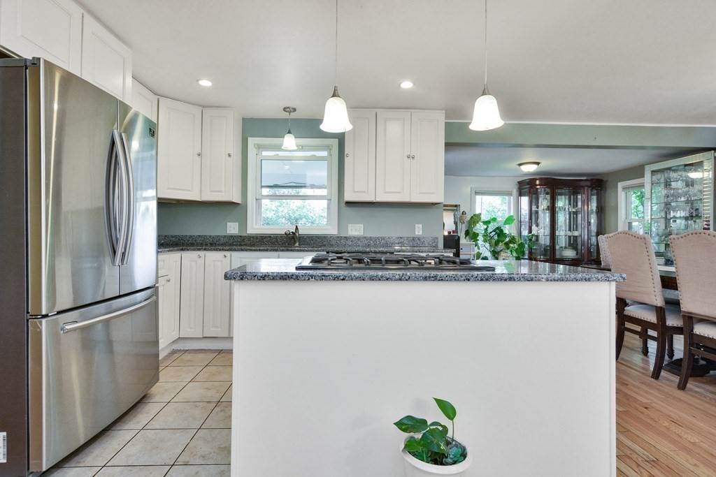39 Oregon Street Springfield, MA 01118 - Photo 6 of 40 a kitchen with stainless steel appliances granite countertop a refrigerator a sink a stove a dining table and chairs