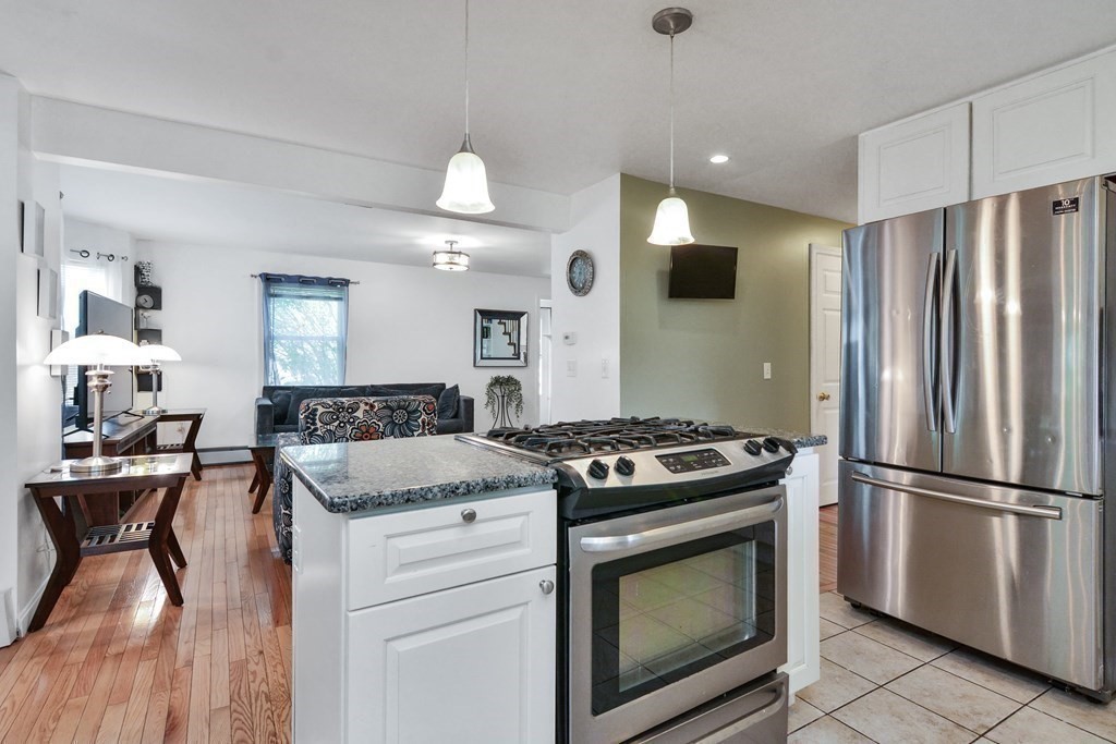 39 Oregon Street Springfield, MA 01118 - Photo 7 of 40 a kitchen with granite countertop a stove and a refrigerator
