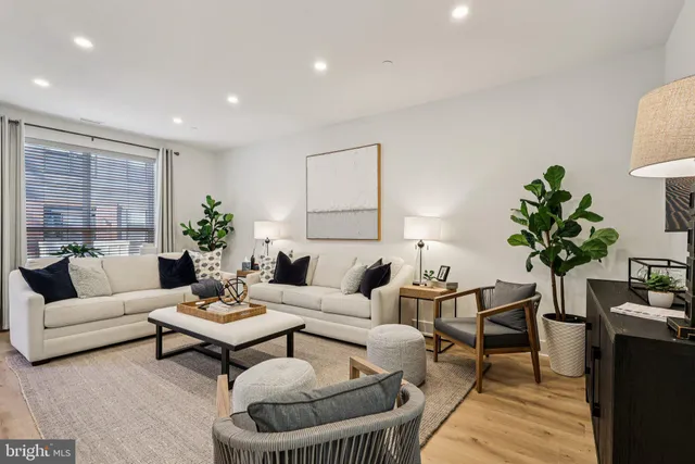 a living room with furniture kitchen view and a refrigerator