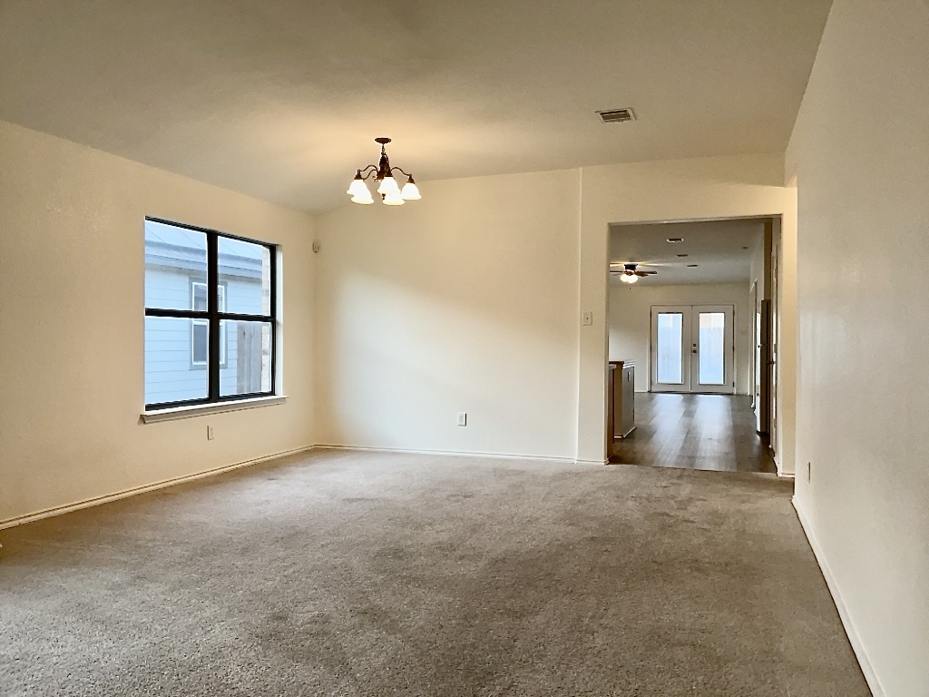 704 Big Sur Trail Taylor, TX 76574 - Photo 5 of 18 Empty room with a chandelier, carpet, and a ceiling fan