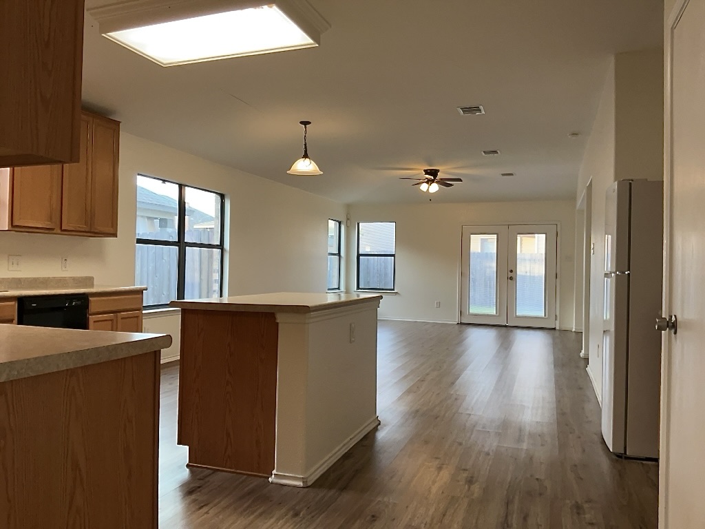 704 Big Sur Trail Taylor, TX 76574 - Photo 6 of 18 Kitchen with hanging light fixtures, freestanding refrigerator, ceiling fan, french doors, and light countertops