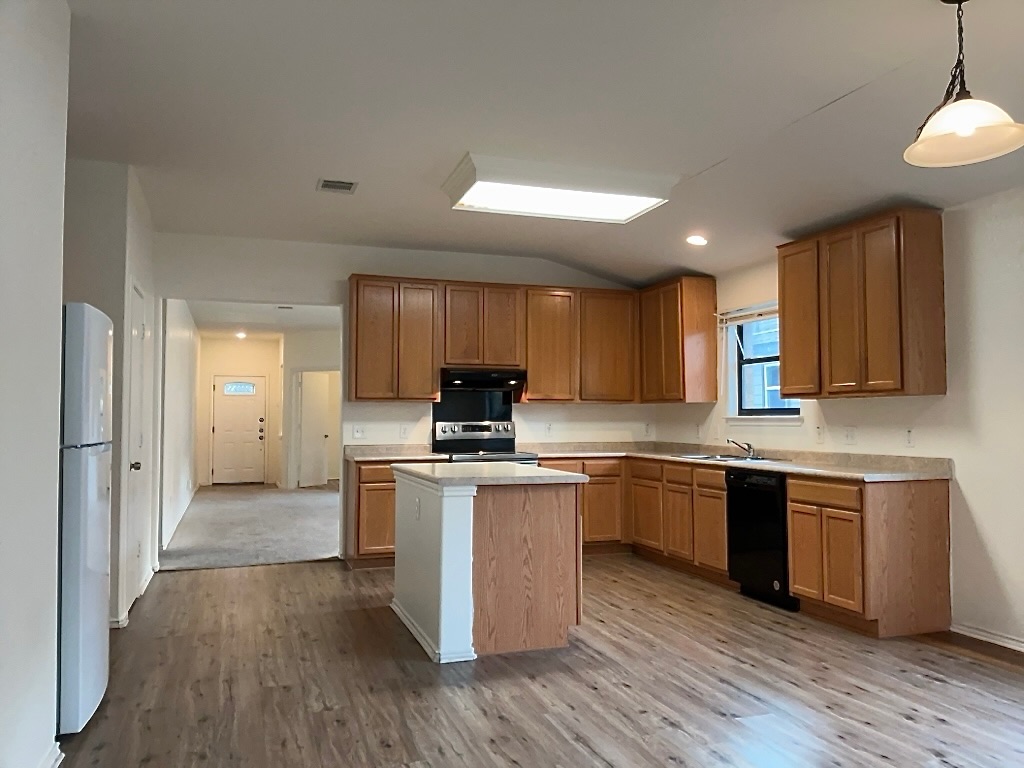 704 Big Sur Trail Taylor, TX 76574 - Photo 8 of 18 Kitchen with light countertops, decorative light fixtures, stainless steel electric stove, freestanding refrigerator, and black dishwasher