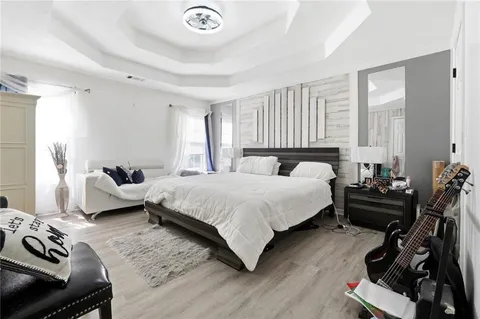 a bedroom with a bed and wooden floor