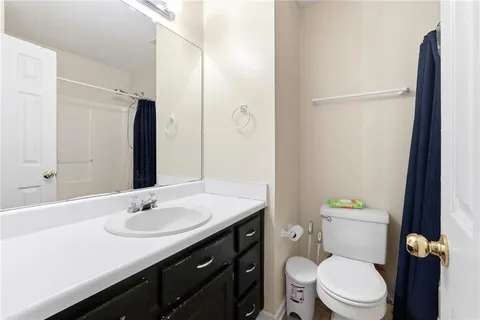 a bathroom with a sink toilet and a mirror