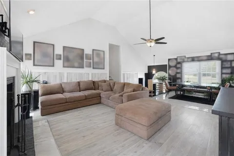 a living room with furniture ceiling fan and a window
