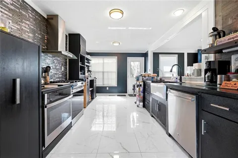 a large kitchen with stainless steel appliances kitchen island granite countertop a large counter top cabinets and stainless steel appliances