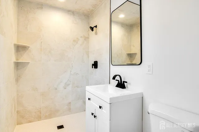 a bathroom with a sink a shower and a mirror