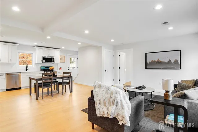 a living room with furniture a dining table and a flat screen tv