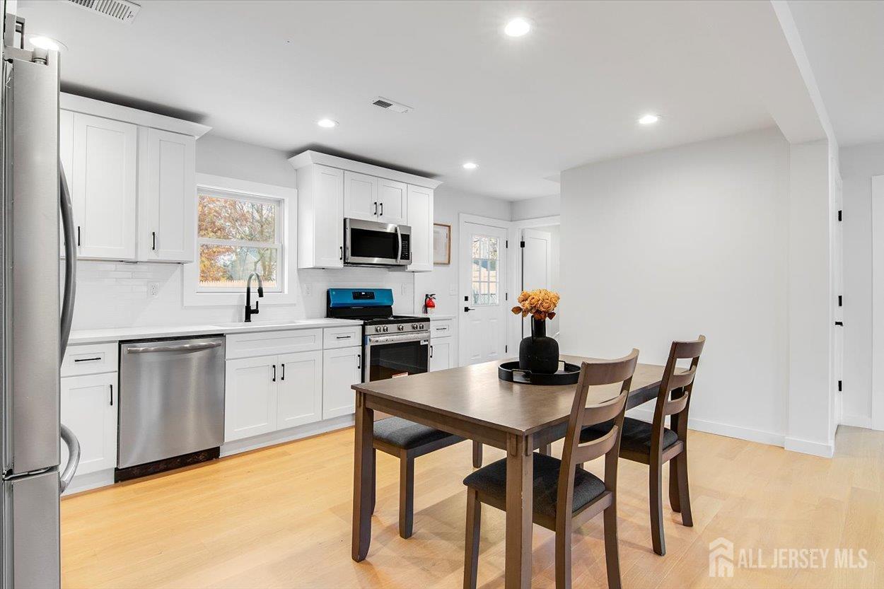 130 Ridge Road Colonia, NJ 07067 - Photo 9 of 28 a kitchen with a dining table chairs and microwave