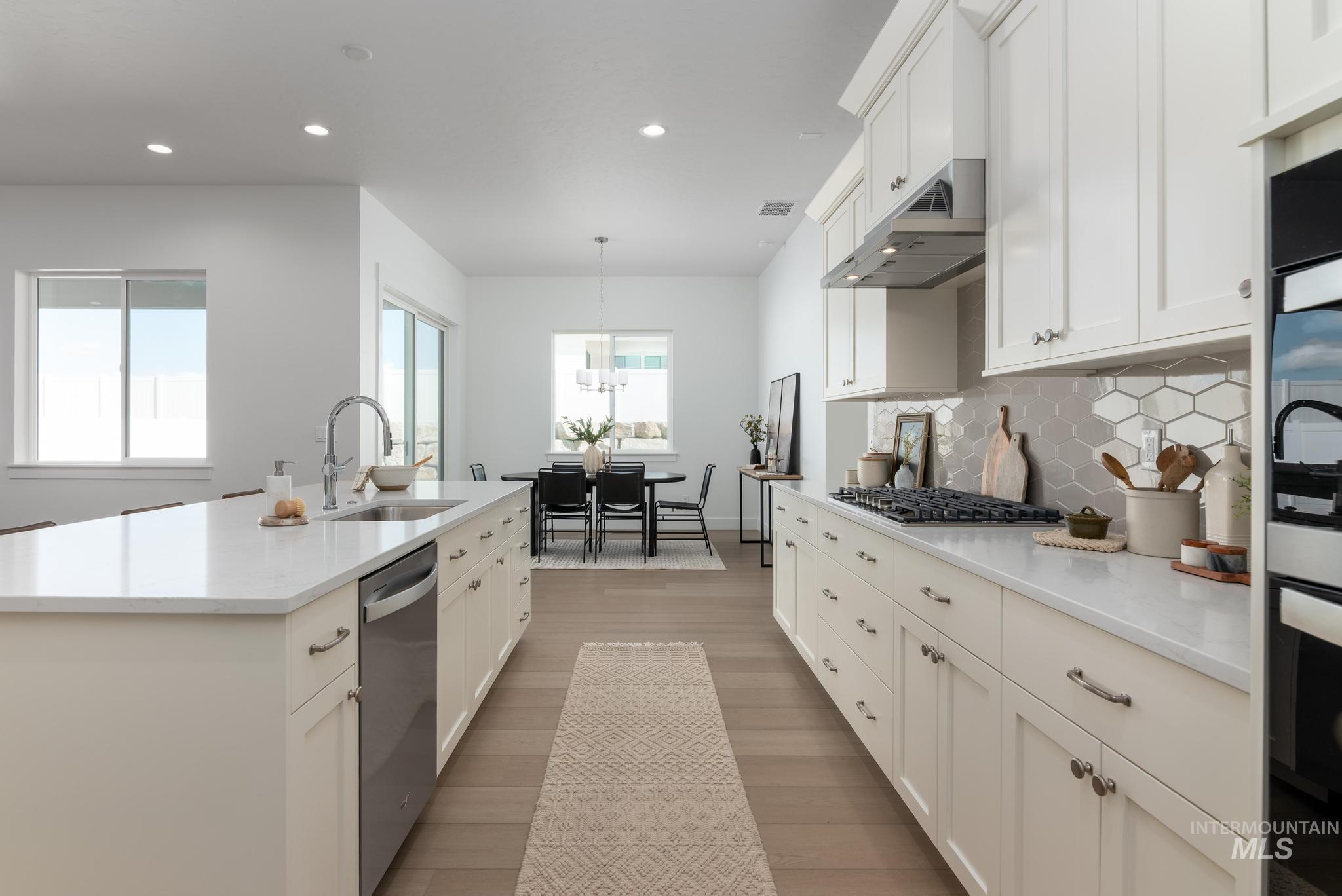 14676 Serenity Pt Street Caldwell, ID 83607 - Photo 16 of 41 Spacious kitchen featuring white cabinetry, light-toned countertops, and a hexagonal tile backsplash