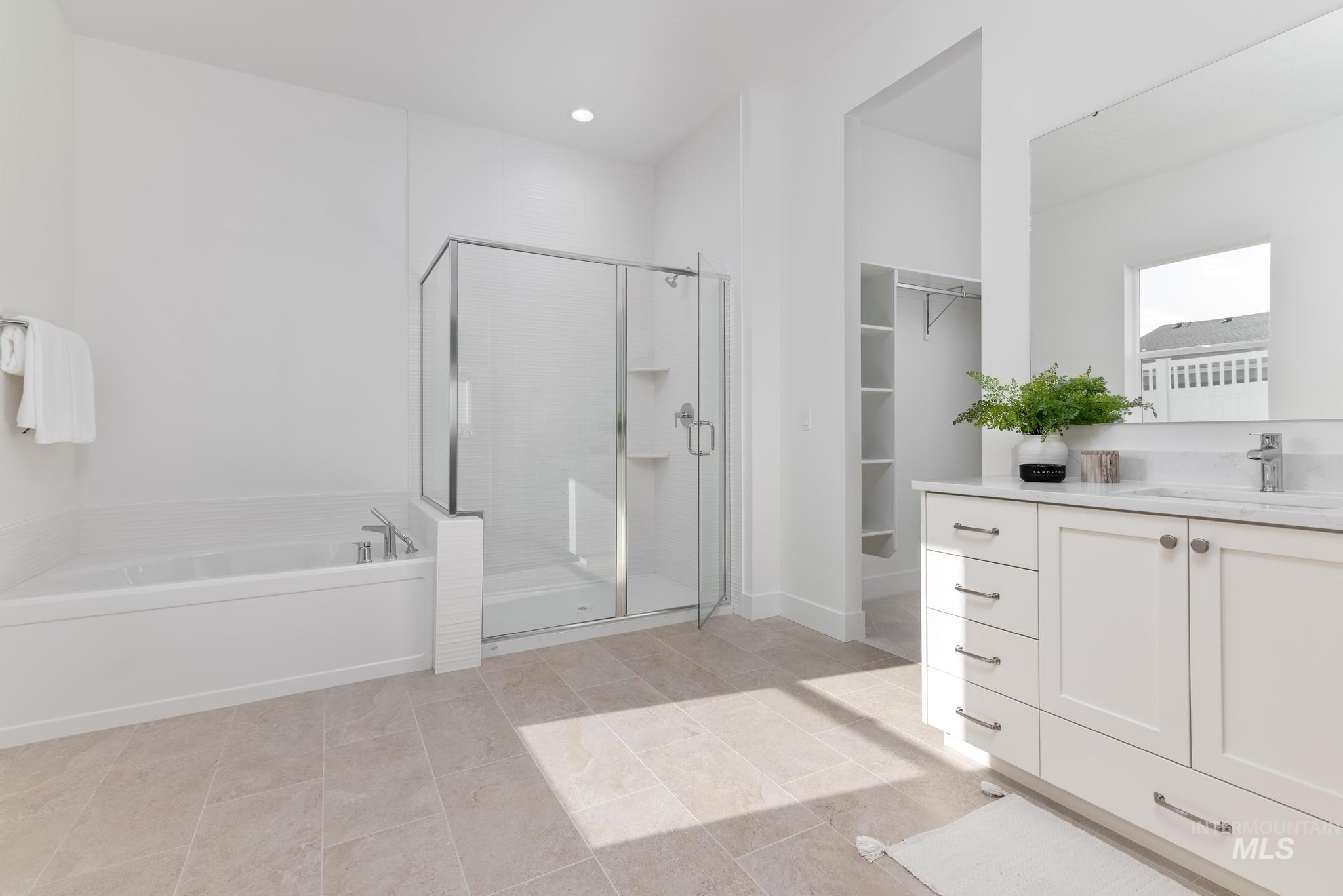 14676 Serenity Pt Street Caldwell, ID 83607 - Photo 21 of 41 Contemporary bathroom featuring a built-in tub, glass-enclosed shower with subway tile, and a double vanity with an integrated sink and large mirror