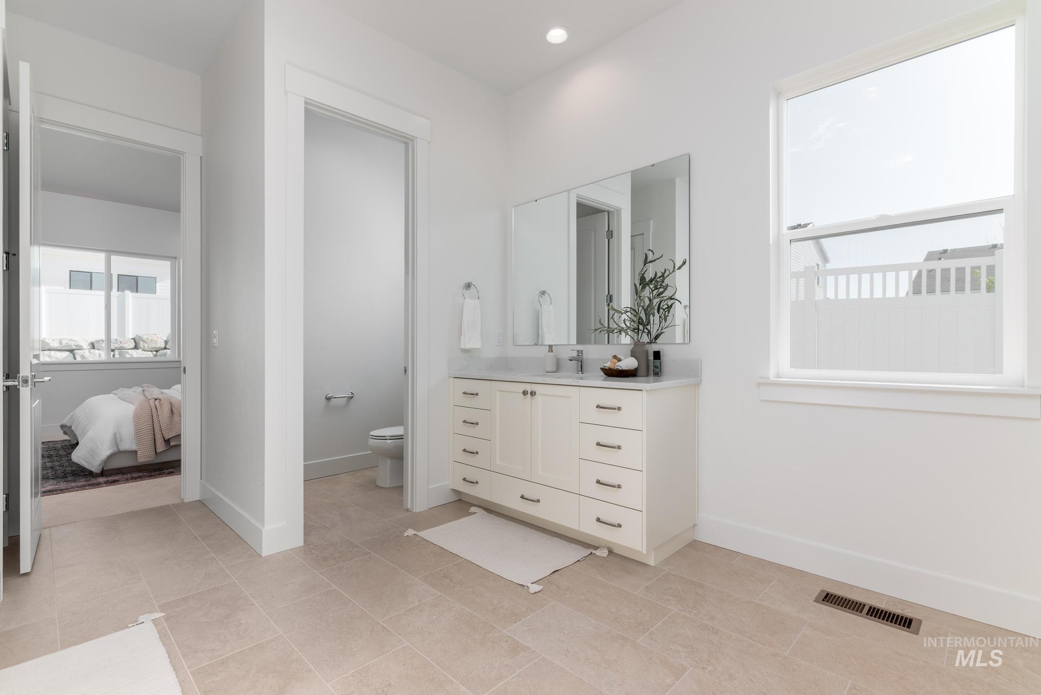 14676 Serenity Pt Street Caldwell, ID 83607 - Photo 22 of 41 Spacious bathroom featuring a double vanity with a light-colored countertop and a large wall-mounted mirror