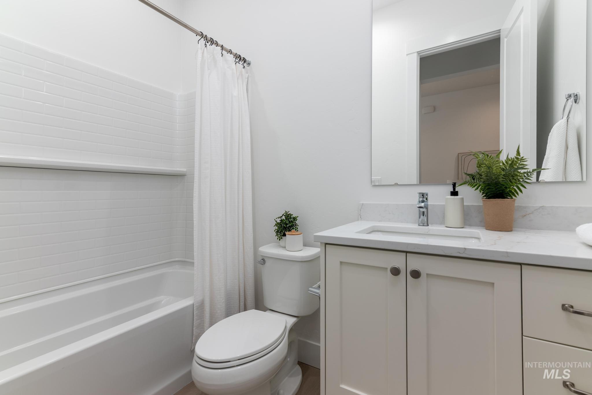14676 Serenity Pt Street Caldwell, ID 83607 - Photo 26 of 41 Bathroom with white subway tile tub surround, chrome shower rod, vanity with a rectangular undermount sink, stone-finish countertop, and chrome faucet