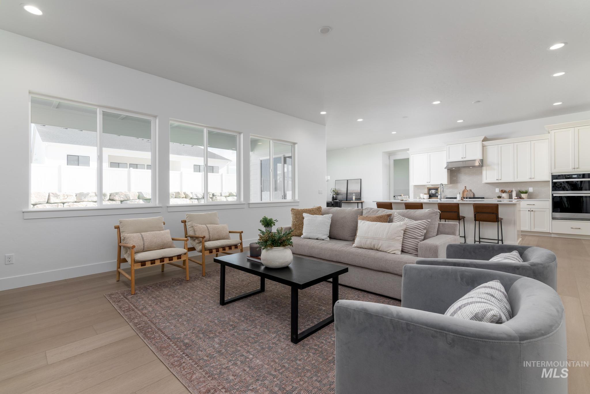 14676 Serenity Pt Street Caldwell, ID 83607 - Photo 8 of 41 Open-concept living area featuring light wood-finish flooring, recessed lighting, and a wall of large windows