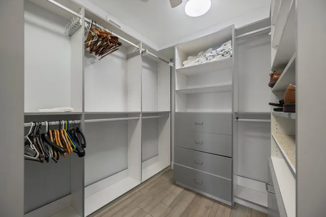 a view of walk in closet with empty racks