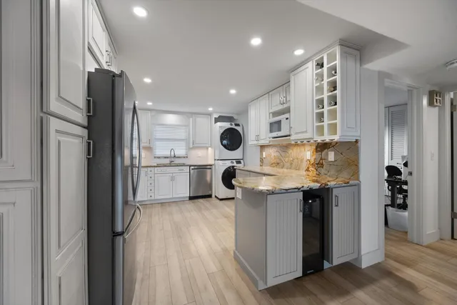 a kitchen with kitchen island a counter top space a sink stainless steel appliances and cabinets