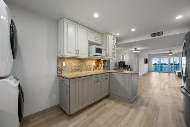 a kitchen with sink a refrigerator and wooden floor