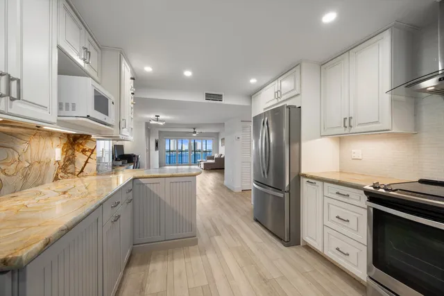 a kitchen with stainless steel appliances granite countertop a refrigerator and a stove top oven