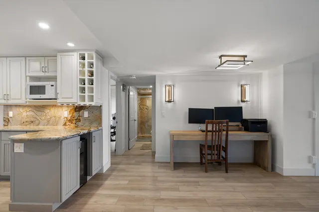 a living room with stainless steel appliances kitchen island granite countertop a sink and cabinets