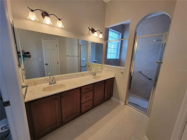a bathroom with a double vanity sink and a mirror