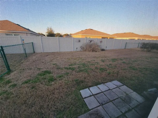 a view of a backyard with a barbeque and wooden fence