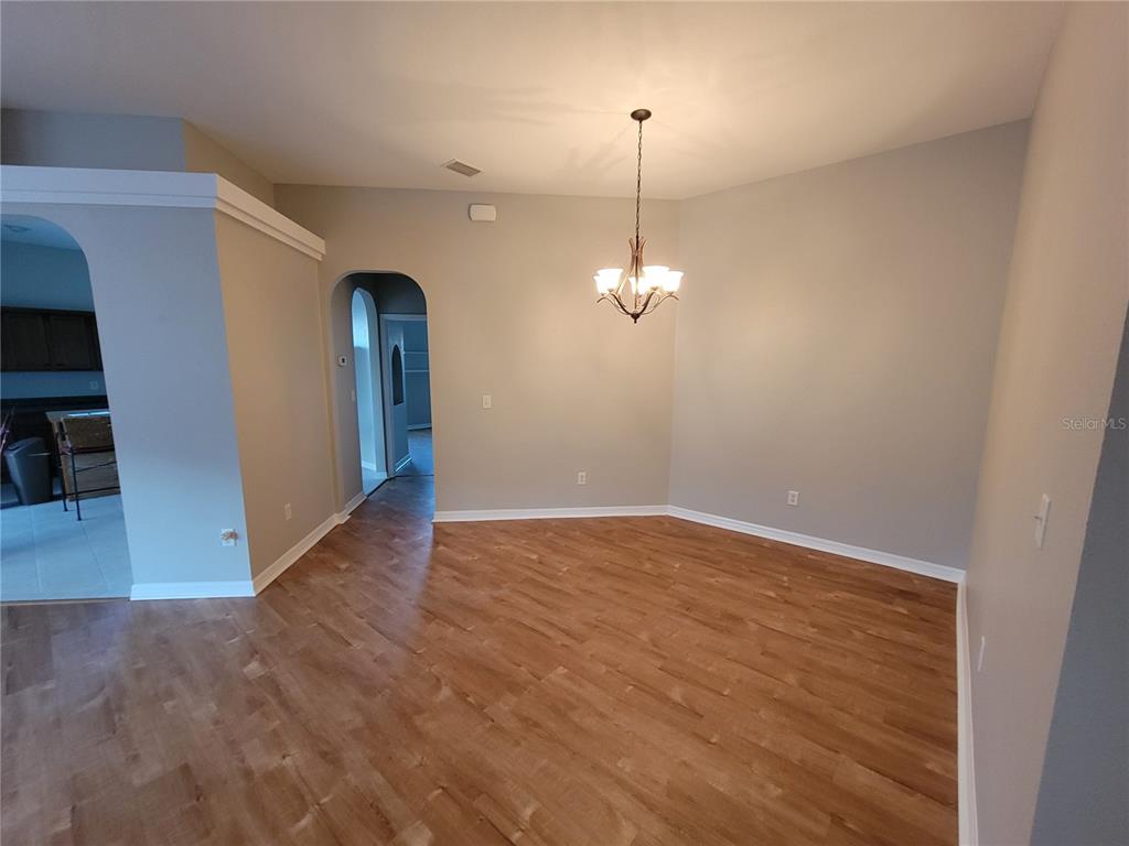 6243 Southwest 90th Street Ocala, FL 34476 - Photo 3 of 13 a view of an empty room with wooden floor