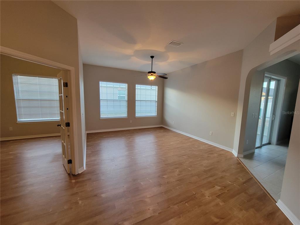 6243 Southwest 90th Street Ocala, FL 34476 - Photo 4 of 13 an empty room with wooden floor and windows