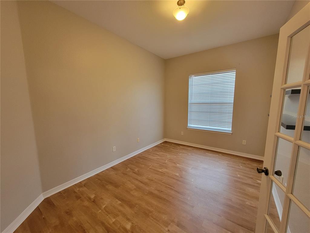 6243 Southwest 90th Street Ocala, FL 34476 - Photo 5 of 13 a view of an empty room with a window and wooden floor