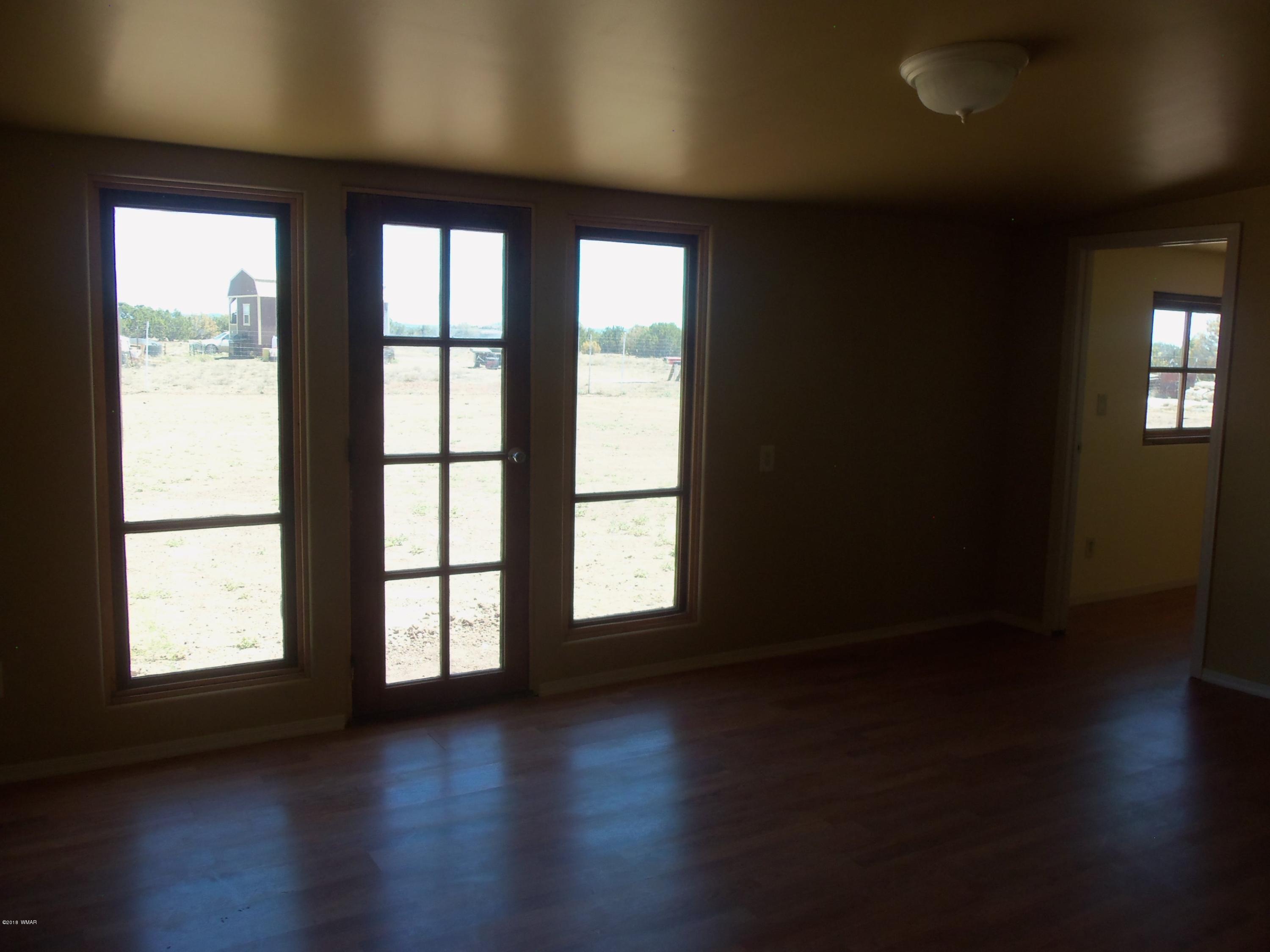 46 8307 Concho, AZ 85924 - Photo 23 of 34 a view of an empty room with wooden floor and a window
