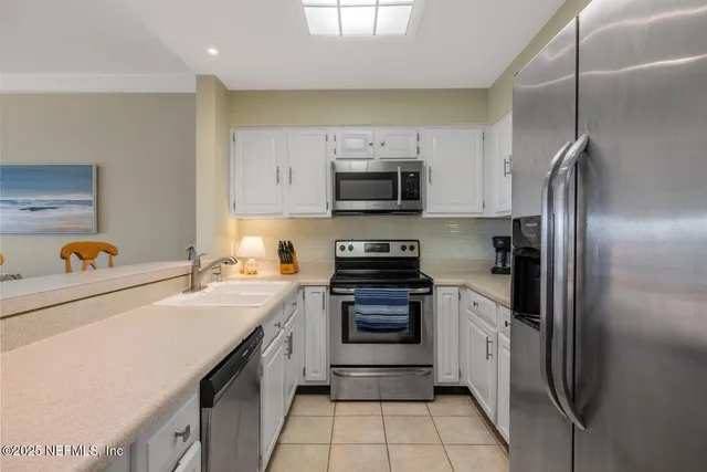 a kitchen with stainless steel appliances a refrigerator sink and microwave