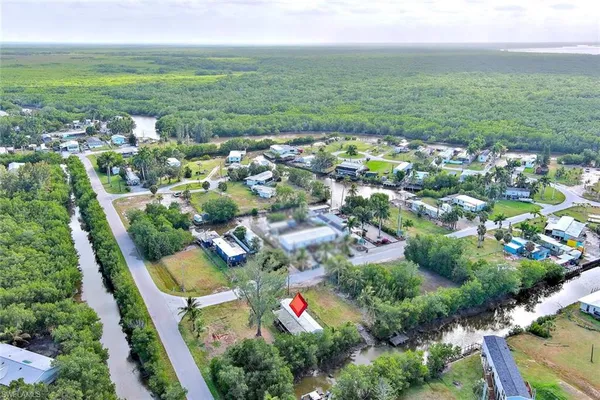 an aerial view of residential houses with outdoor space and trees