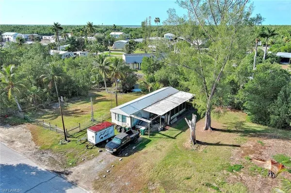 an aerial view of a house with swimming pool and large trees