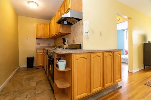 a kitchen with stainless steel appliances granite countertop a sink a stove and a refrigerator