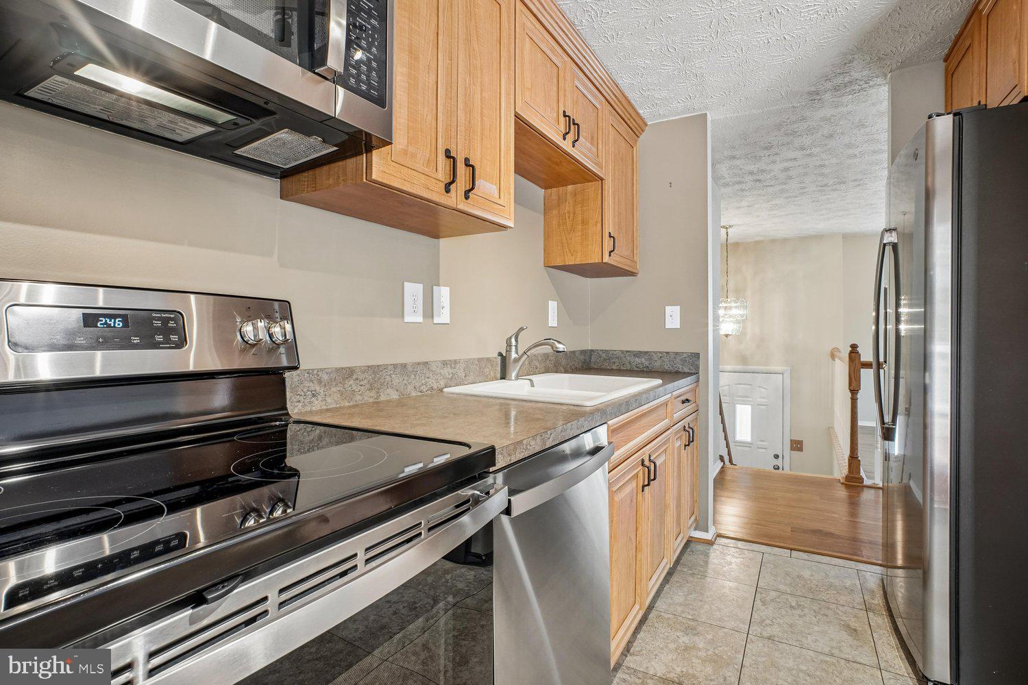 8491 Rippled Creek Court Springfield, VA 22153 - Photo 13 of 40 a kitchen with a sink stove and refrigerator