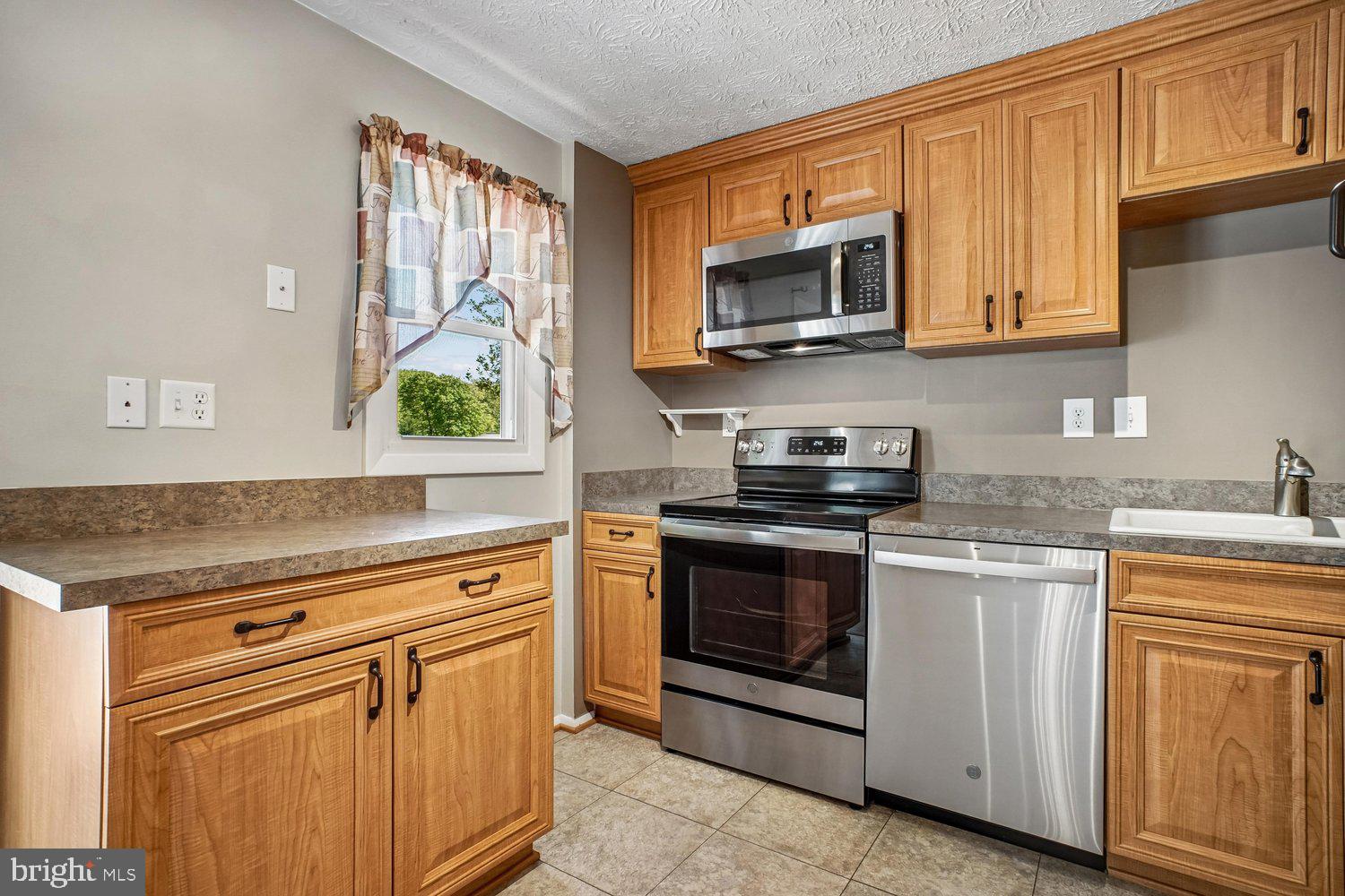 8491 Rippled Creek Court Springfield, VA 22153 - Photo 14 of 40 a kitchen with stainless steel appliances granite countertop a stove a sink and a microwave
