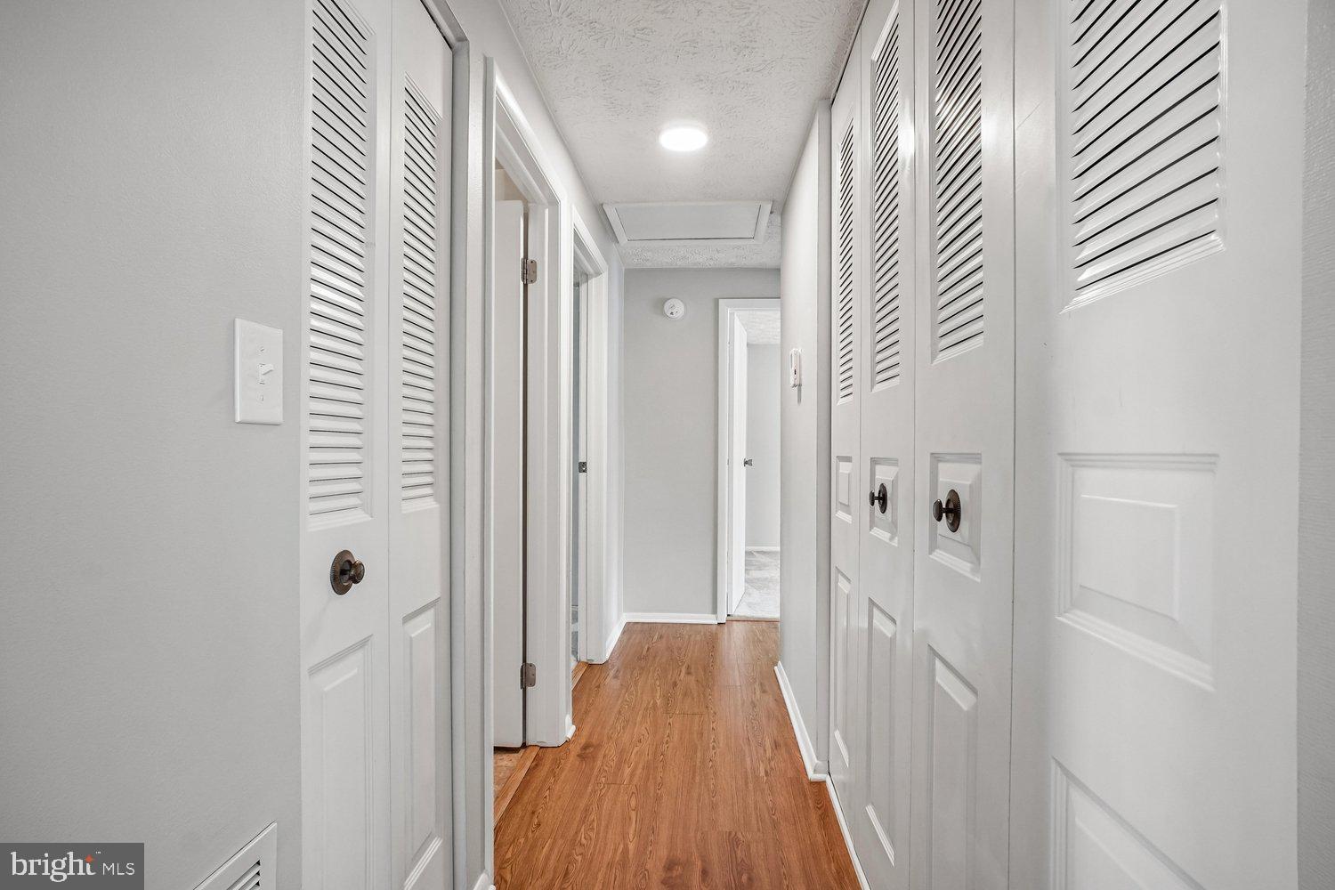 8491 Rippled Creek Court Springfield, VA 22153 - Photo 20 of 40 a view of a hallway with wooden floor and closet