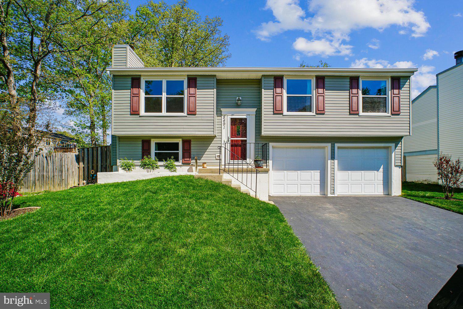 8491 Rippled Creek Court Springfield, VA 22153 - Photo 3 of 40 a front view of a house with a yard and garage