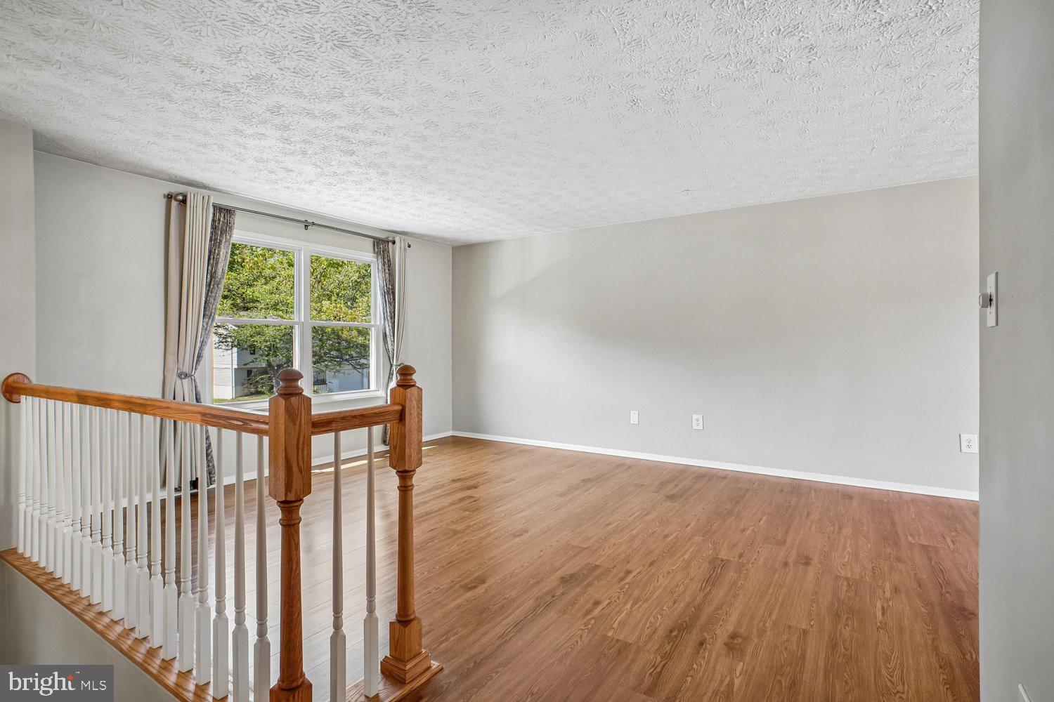 8491 Rippled Creek Court Springfield, VA 22153 - Photo 9 of 40 a view of an empty room with wooden floor and a window