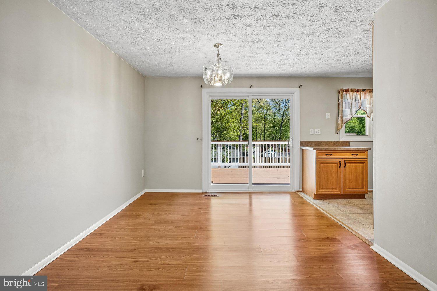 8491 Rippled Creek Court Springfield, VA 22153 - Photo 10 of 40 a view of an empty room with wooden floor and a window