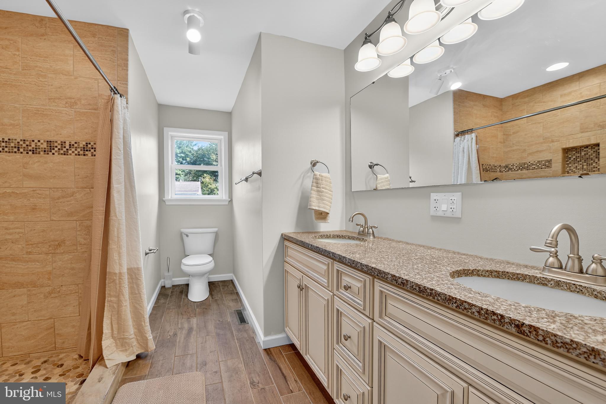 1 Spring Avenue Temple, PA 19560 - Photo 17 of 34 a spacious bathroom with a granite countertop sink a toilet and a mirror